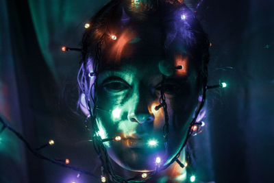 Close-up portrait of young woman with light painting