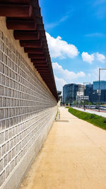 Footpath amidst buildings against sky