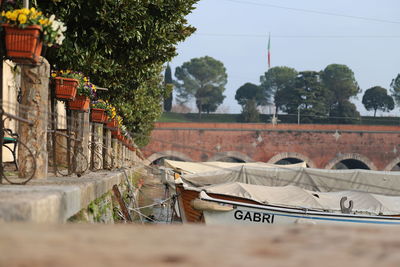 Boats moored by building against sky