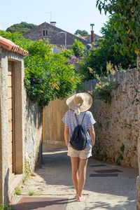 Rear view of woman walking against building