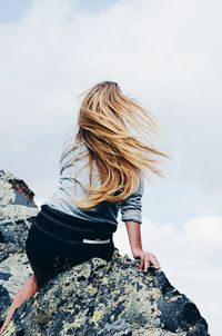 Rear view of young woman sitting on bench