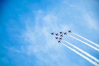 Low angle view of airplanes against blue sky