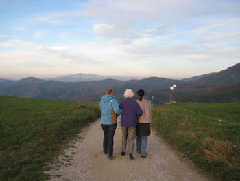 Rear view of woman standing on mountain landscape