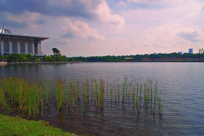 Scenic view of lake by buildings against sky