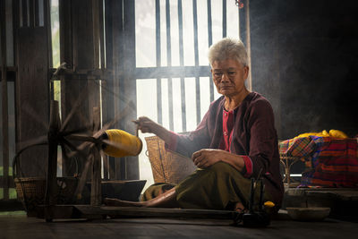 Portrait of woman with arms raised sitting at home