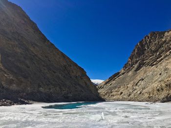 Scenic view of mountains against clear blue sky