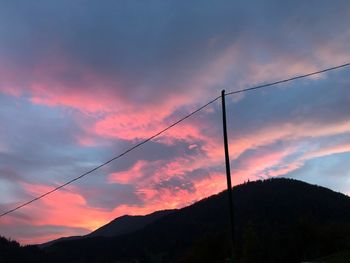 Low angle view of silhouette mountain against dramatic sky