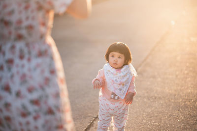 Midsection of mother with daughter standing on road