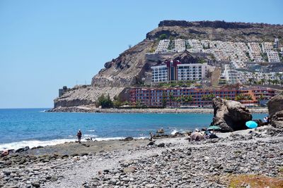 Scenic view of sea by buildings against clear sky