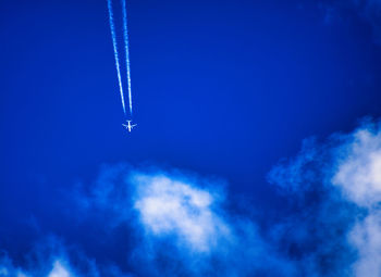 Low angle view of vapor trail in blue sky