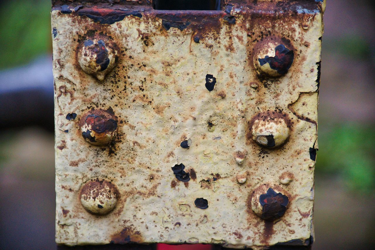 CLOSE-UP OF OLD RUSTY METAL ON WOOD
