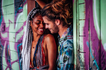 SMILING YOUNG COUPLE KISSING ON BED