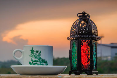 Close-up of metallic structure on table against sky during sunset