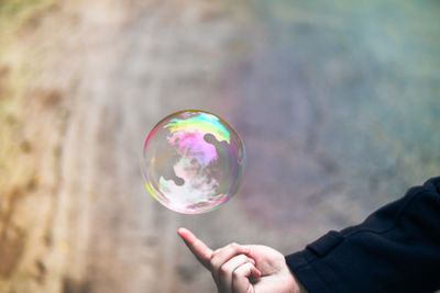 Close-up of hand below bubble