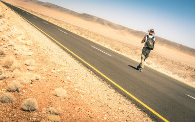 Man walking on road against sky