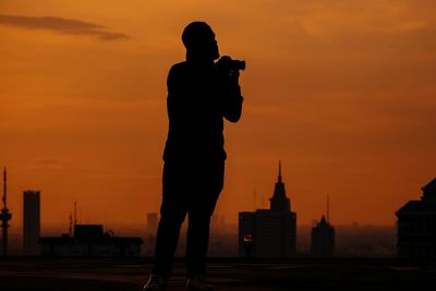 Silhouette man standing against sky during sunset