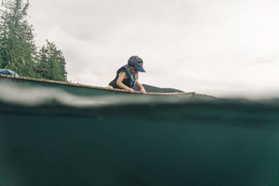 A young girl rides in a canoe with her dad on lost lake in oregon.