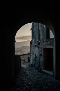 Alley amidst buildings in city against sky