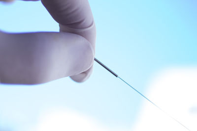 Cropped hand holding acupuncture needle in hospital