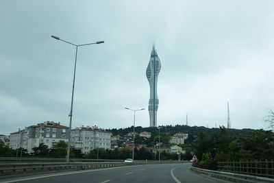 View of city street against cloudy sky