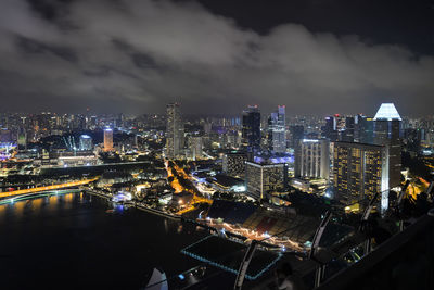 High angle view of illuminated buildings against sky at night