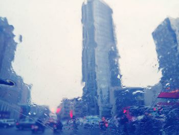 Close-up of wet window against blue sky