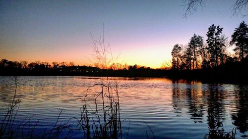 Scenic view of lake against sky at sunset