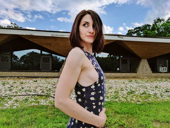 Side view of woman looking away while standing on field