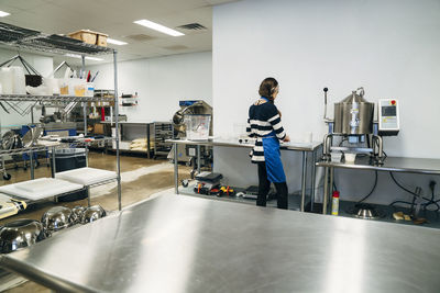 Rear view of woman working in chocolate factory