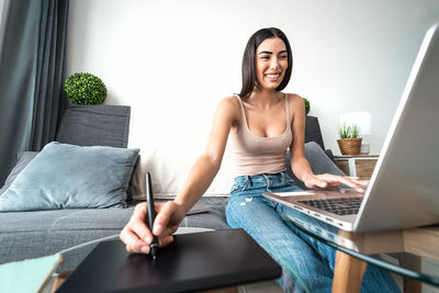 Young woman using mobile phone at home