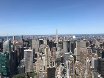 Aerial view of cityscape against blue sky