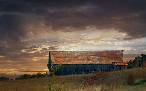 Built structure on field against sky during sunset