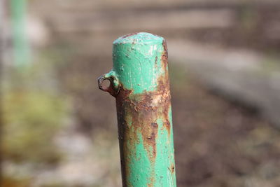 Close-up of rusty metal on wooden post