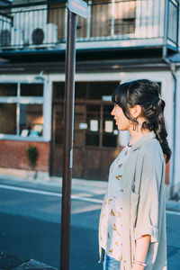 Woman standing by window in city