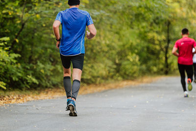 Rear view of man jogging on road