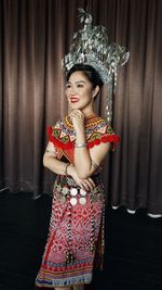 Smiling woman wearing traditional clothing standing on stage