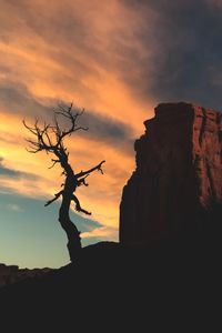 Silhouette of cliff against sky during sunset