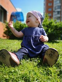 Smiling baby girl sitting on field