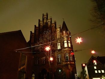 Low angle view of illuminated building against sky at night