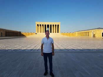 Full length of man standing in city against clear sky