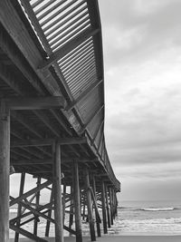 Low angle view of pier over sea against sky