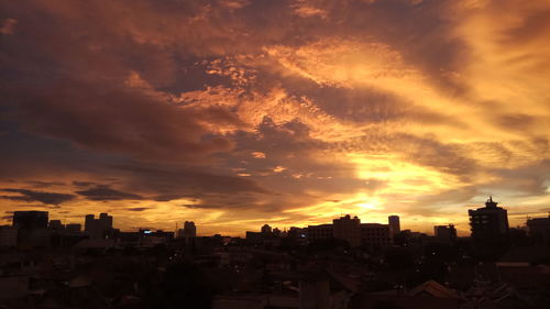 View of cityscape against cloudy sky during sunset