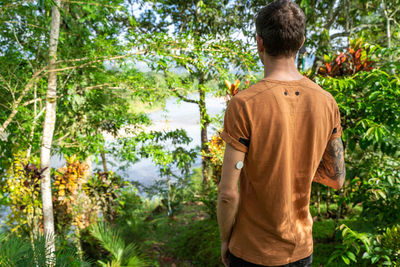 Rear view of man standing against trees