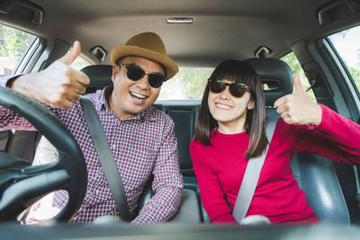 Portrait of smiling young woman sitting in car