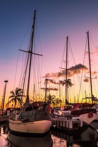 Sailboats in sea at sunset