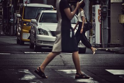 Low section of woman standing on city street