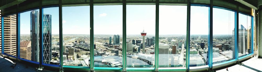 Panoramic view of cityscape seen through glass window