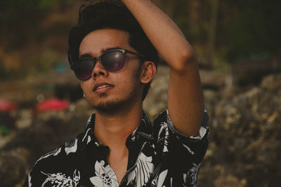 Portrait of young man wearing sunglasses standing outdoors