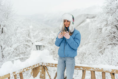 Portrait of woman standing in snow