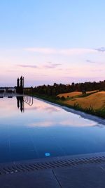 Swimming pool against sky during sunset